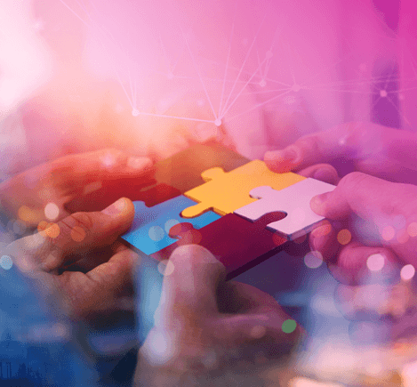 muchas manos toman un rompe cabezas de multiples colores