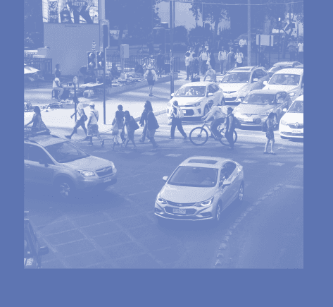 Imagen en tonos azules de una calle, hay autos y peatones cruzando.