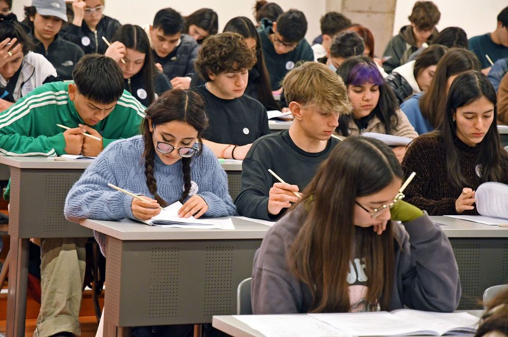 Grupo de estudiantes concentrados rindiendo una prueba.