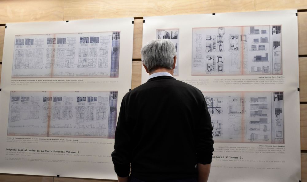 Fotografía con una persona mirando los planos de la exposición