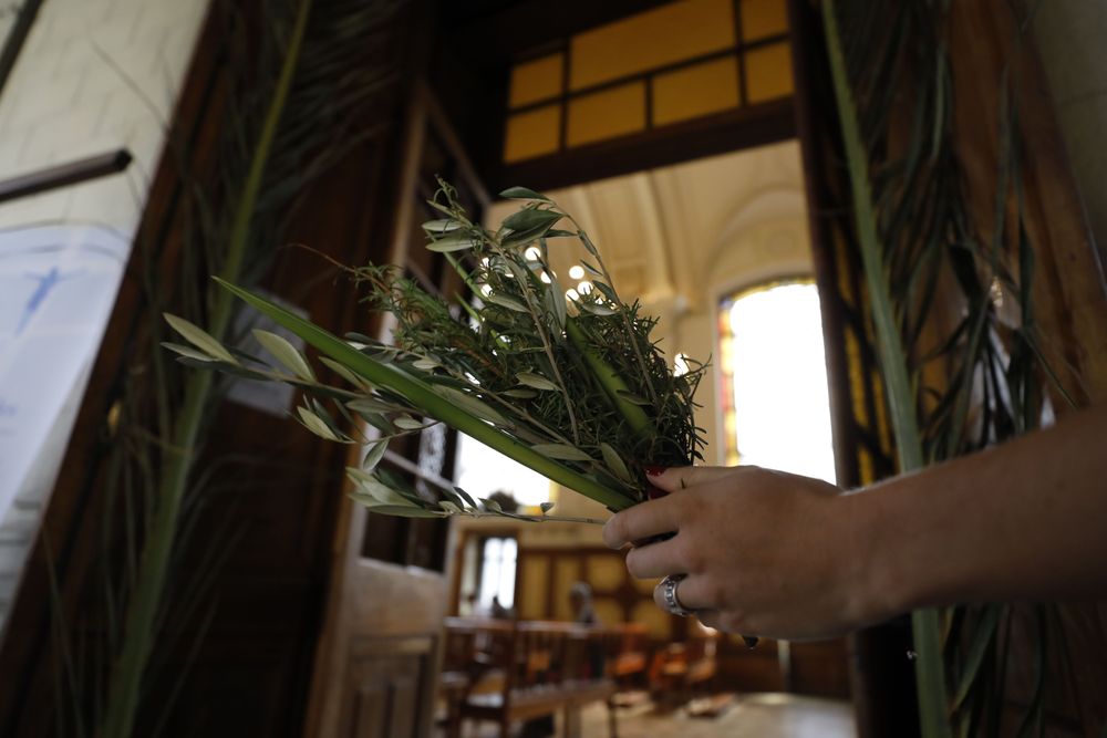 Persona sosteniendo un ramo a la entrada de una capilla