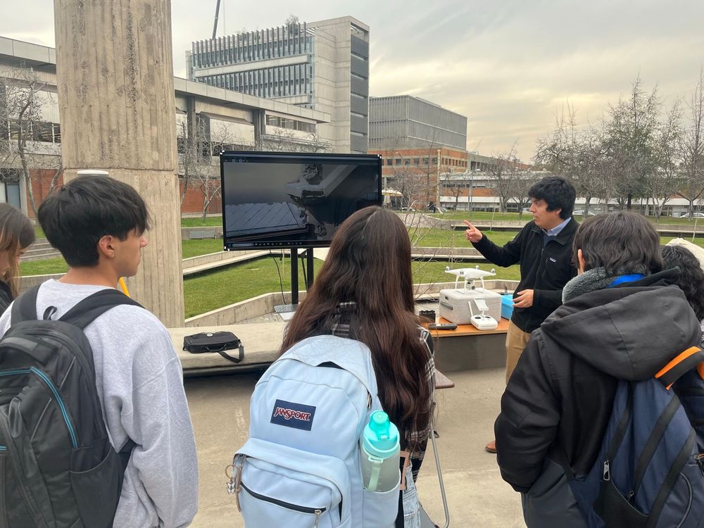 docente con interesados en la carrera mostrando uso de drones