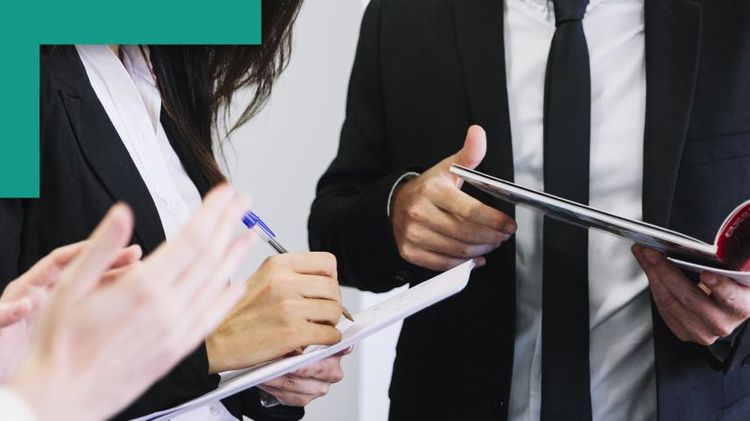 3 personas trabajando, una anotando, esta hablando y otra con una revista, solo se visualizan los torsos y manos