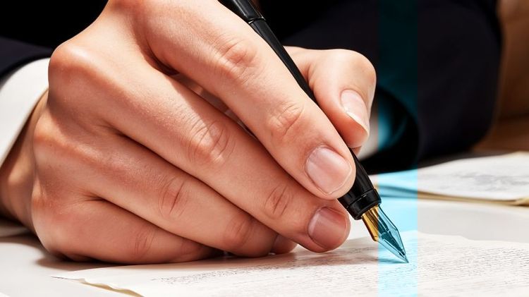 Mano escribiendo con una pluma