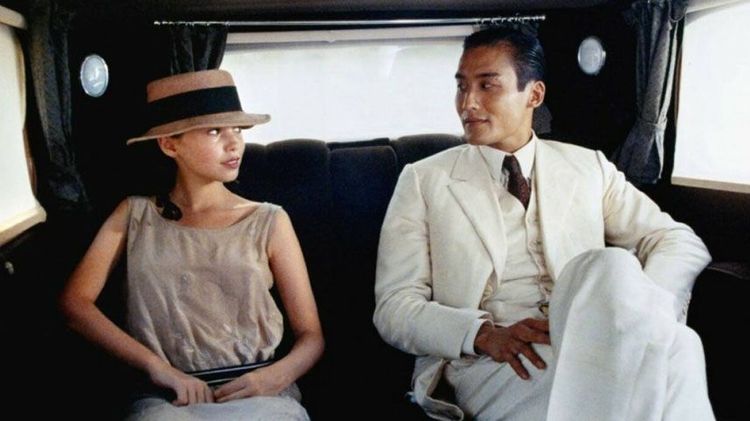 Imagen de una escena de la película "El amante". La pareja protagonista aparece sentada en un auto mirándose uno al otro.