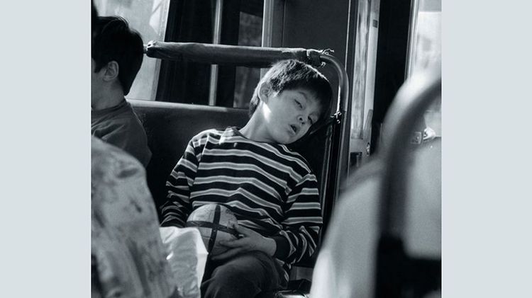Fotografía de la portada del libro "Formas de volver a casa". En la foto aparece un niño durmiendo en una micro.