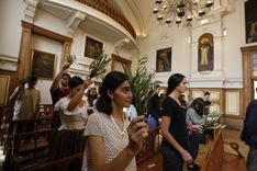 Personas sostienen sus ramos en dirección al altar