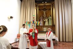 Un sacerdote sostiene una cruz con cintas