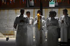 Un grupo de hombres camina alrededor de un cirio